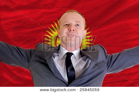Glad affärsman på grund av lönsamma investeringar i Kirgizistan som står nära flagga