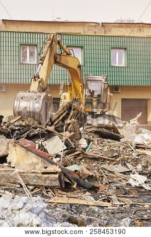 Demolition House Using Excavator In City. Rebuilding Process. Remove Equipment