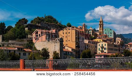 Colorful Old Buildings Perched Atop A Hill In The Medieval Town Of Vintimiglia In Italy, Just Across