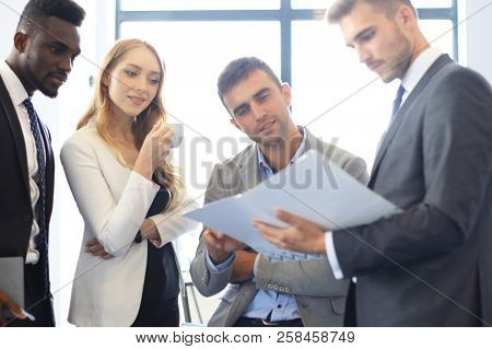 Young Modern Colleagues In Smart Casual Wear Having A Brainstorm Meeting While Standing In The Creat