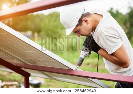 Profile Of Professional Technician Working With Screwdriver Connecting Solar Photo Voltaic Panel To 