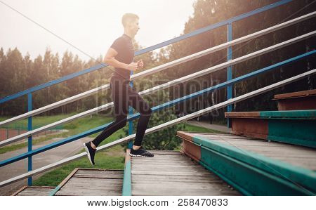 Young Man Runner Runs Up Stairs Of Stadium.