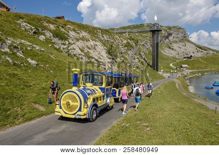 Melchsee-frutt, Switzerland - 4 August 2018: People Walking And Travelling On A Tourist Train At Mel