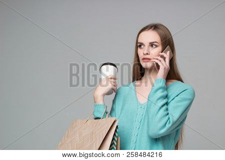 Girl In Aquamarine With Bags, Paper Glass, Talks By Smartphone