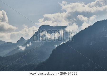 Scenic View Of Misty Mountains Above Halstatt Village In Austria.