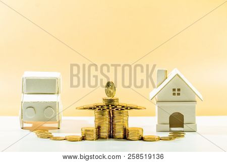 Stacked Gold Coin With Grow Value And House And Car Model Put On Brown Background In The Office, Sav