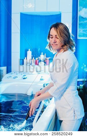 Young Woman During Hydromassage In Beauty Salon. Concept Of Body Care And Spa. The Masseuse Massages
