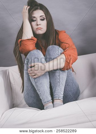 Worried Woman Sitting On Sofa