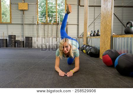 Slim Young Healthy Sports Woman Doing The Donkey Kick Exercise On All Fours Arching Back Straighteni