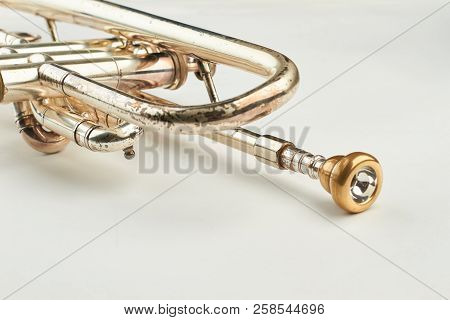 Rusty Trumpet With Mouthpiece Close Up. Part Of Classical Trumpet On Light Background. Design Of Ret