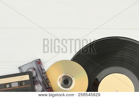 Musical Storage Devices And Copy Space. Old Audio Cassette Tapes, Compact Disc And Vinyl Record On W