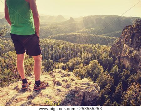 Green Singlet And Black Pants Fearless Boy In Rocks. Amazing View Into Wild Nature Landscape.