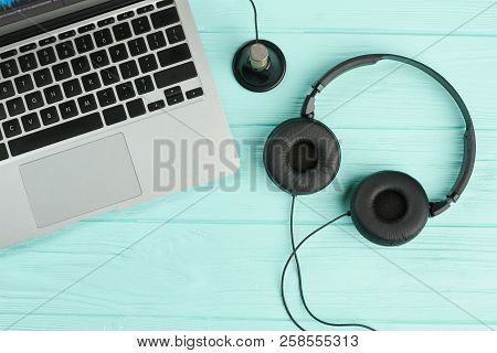 Laptop And Headphones On Blue Background. Portable Laptop With Headset And Mini Stereo Microphone On