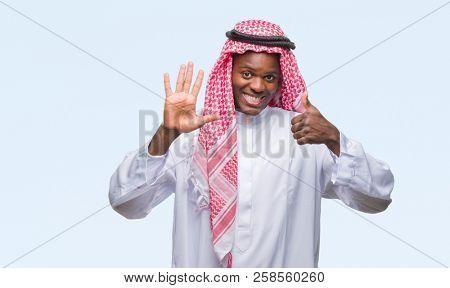 Young arabic african man wearing traditional keffiyeh over isolated background showing and pointing up with fingers number six while smiling confident and happy.