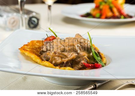 Beef Stroganoff On Pancakes Made From Cathofiot With Tomatoes And Peppers, Pancakes From Potatoes