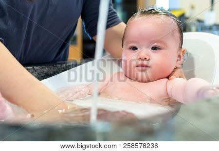 Baby Boy Taking A Bath In A Little Bath Tub