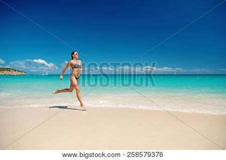 Woman With Beautiful Body In Swimsuit Running In Ocean Water Sunny Day At Tropicl Beach, Sport And W