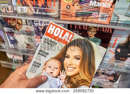 Miami, Usa - August 22, 2018: Hola Magazine In A Hand Over A Stack Of Magazines. Hola Is A Popular W