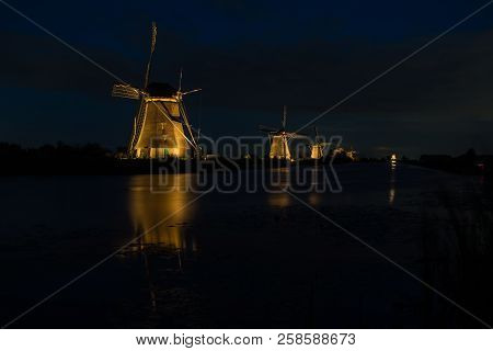 These Beautiful Windmills In Kinderdijk Are Illuminated With White Light At The Blue Hour