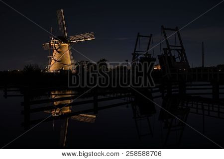 These Beautiful Windmills In Kinderdijk Are Illuminated With White Light At The Blue Hour