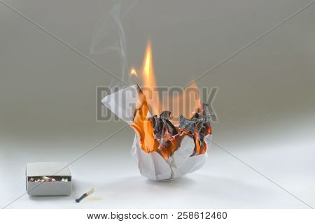 Crumpled Paper Burning In Fire And Matchbox . Burning White Paper Ball In Flame And Box Of Matches.