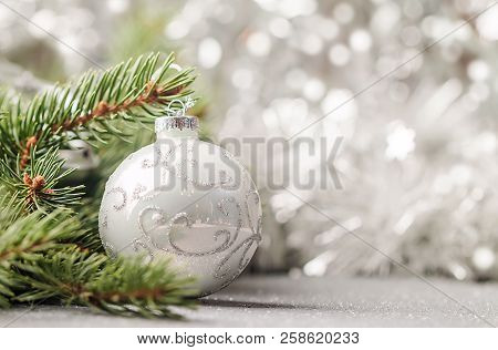 Silver Christmas Background Of Defocused Bokeh Lights With Decorated Fir Tree Branches