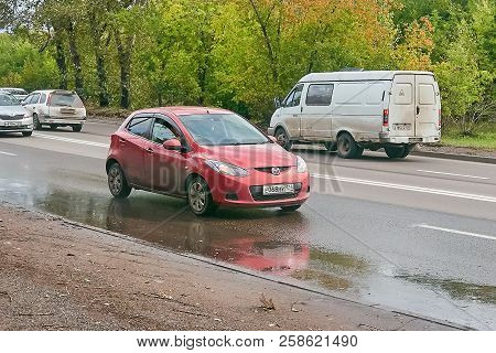 Krasnoyarsk, Russia - September 16, 2018: Mazda Demio Car With The Trailer Moves On The Country Road