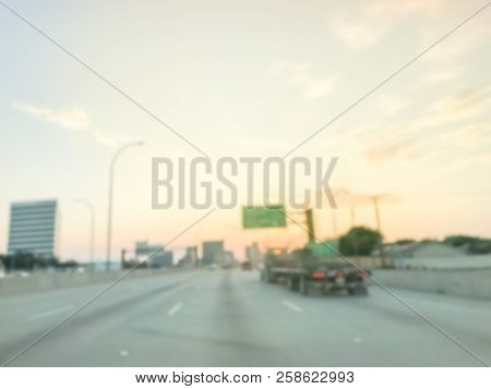 Blurry Background Long Vehicles Commute On Highway Near Green Road Signs At Sunrise