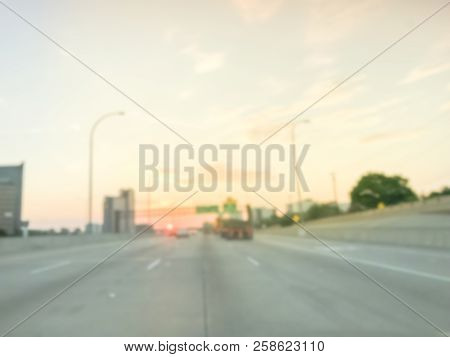 Blurry Background Long Vehicles Commute On Highway Near Green Road Signs At Sunrise