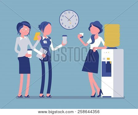 Office Cooler Chat. Young Female Workers Having Informal Conversation Around A Watercooler At Workpl