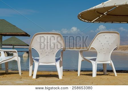 Plastic Chairs On Salty Lake Dead Sea, Full Of Minerals Near Luxury Vacation Resort Ein Bokek, Perfe