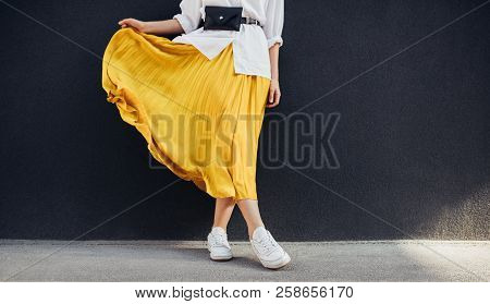 Cropped Body Shot Of Attractive Woman In Beautiful Yellow Skirt. Caucasian Female Fashion Model Stan