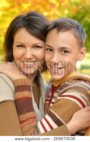 Close Up Portrait Of Mother With Son Hugging Outoors