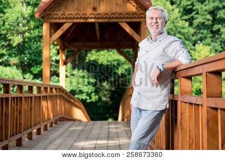 Happy Aged Man Feeling Good And Smiling While Standing On The Bridge