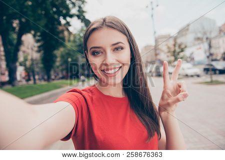 Self-portrait Of Straight-haired Young Beautiful Smiling Girl Wearing Casual Red T-shirt Outside, Tr