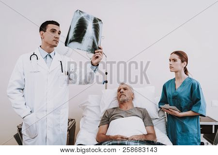 Doctor Look At Photo. Doctor And Nurse. Doctor And Nurse Hepl Patient. Clinic And Sick Old Man. Clin