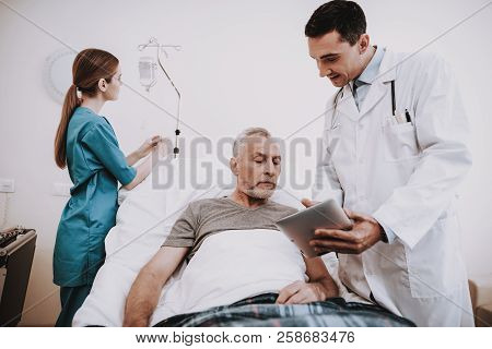 Nurse Doctor And Patiend In Clinic. Doctor And Patien. Patient And Nurse. Patiend In White Room With