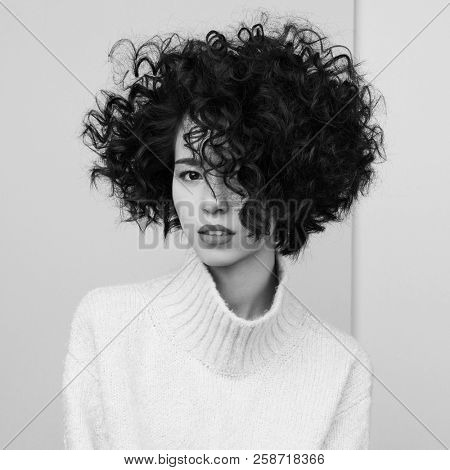 Studio fashion portrait of beautiful asian woman in oversize pullover on colorful pastel background. Stylish look book. Autumn Winter season. Bright spring