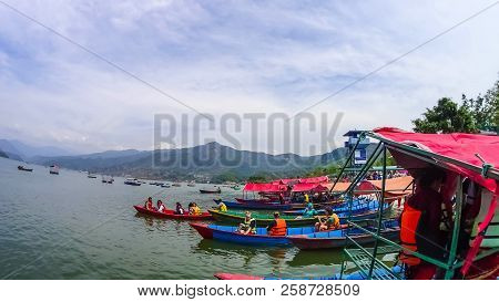 Pokhara, Nepal - April 10, 2018: The People Sitting At Colorful Wooden Boat At Fewa Lake In Pokhara,