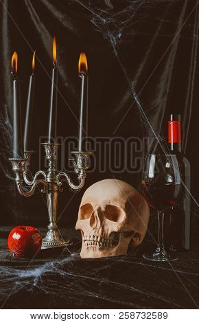 Halloween Skull, Apple, Red Wine And Candelabrum With Candles On Black Cloth With Spider Web
