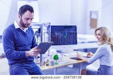Concentrated Young Man Working With Portative Gadget