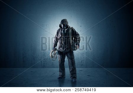 Bad agent in a dark room with arms on his hand and gas mask