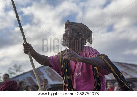 Bajawa, Indonesia - May 19: An Unidentified Man Dances With A Wooden Pole And Traditional Scarf Near