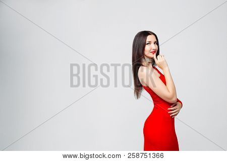 Seductive Brunette In Bright Red Dress And Chocker With Hand At
