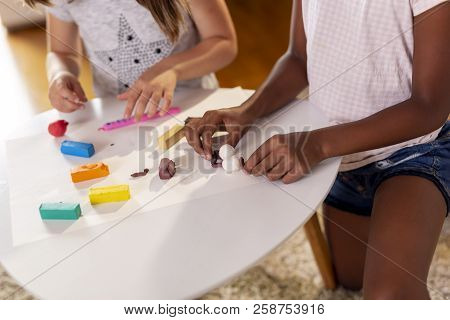 High Angle View Of Two Preschoolers Playing With Colorful Plasticine And Having Fun. Focus On The Sn