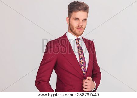 happy handsome businessman smiling at the camera on grey background