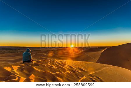 Woman Enjoing Sunrise In The Sahara Desert Next To M'hamid In Morocco
