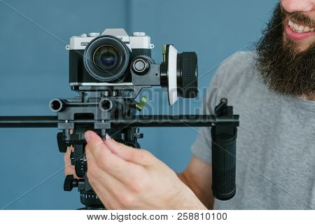 Video Content Creation Process. Man Holding Camera And Shooting Footage For Vlog Broadcast Or Report