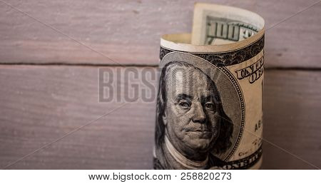 A One Hundred Dollar Bils On Wooden Background
