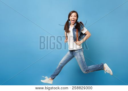 Full Length Portrait Of Young Excited Cheerful Woman Student With Opened Mouth With Backpack Jumping